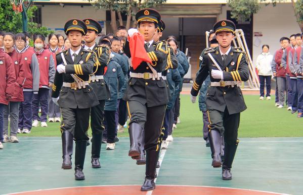 2校國旗班與行至六班學(xué)生代表執(zhí)行升旗儀式